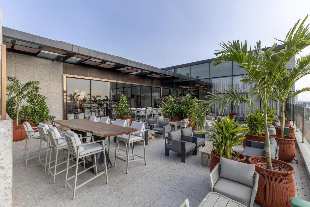 a patio with a table and chairs and plants at Radisson Blu Hotel Pune Kharadi in Pune