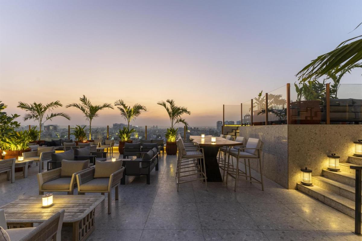 a restaurant with tables and chairs on a roof at Radisson Blu Hotel Pune Kharadi in Pune