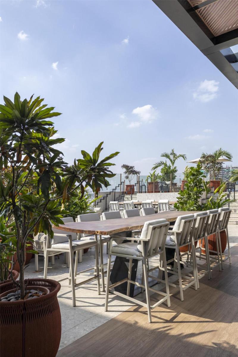 a table and chairs on a patio with the ocean at Radisson Blu Hotel Pune Kharadi in Pune