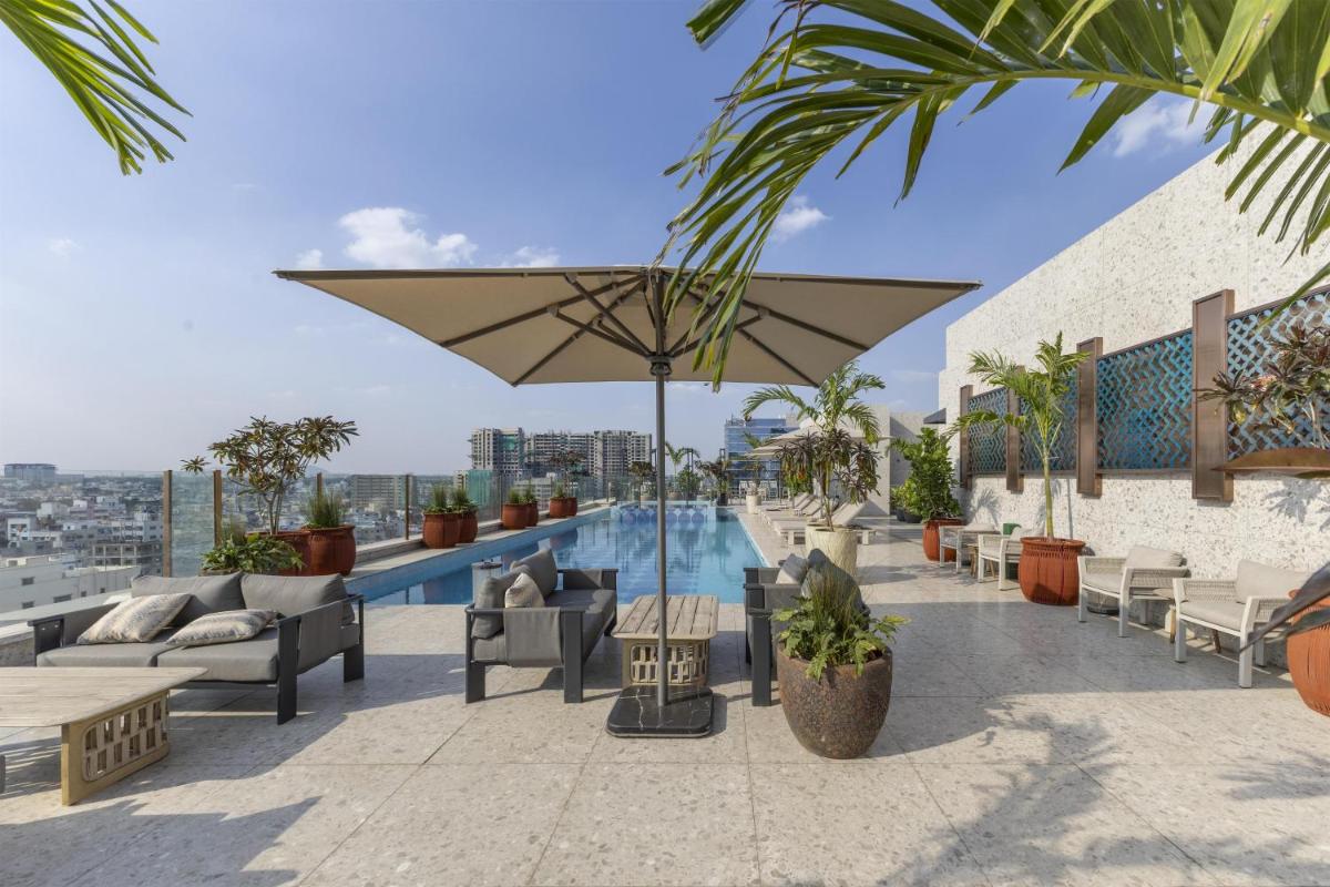 a hotel rooftop with a swimming pool and an umbrella at Radisson Blu Hotel Pune Kharadi in Pune