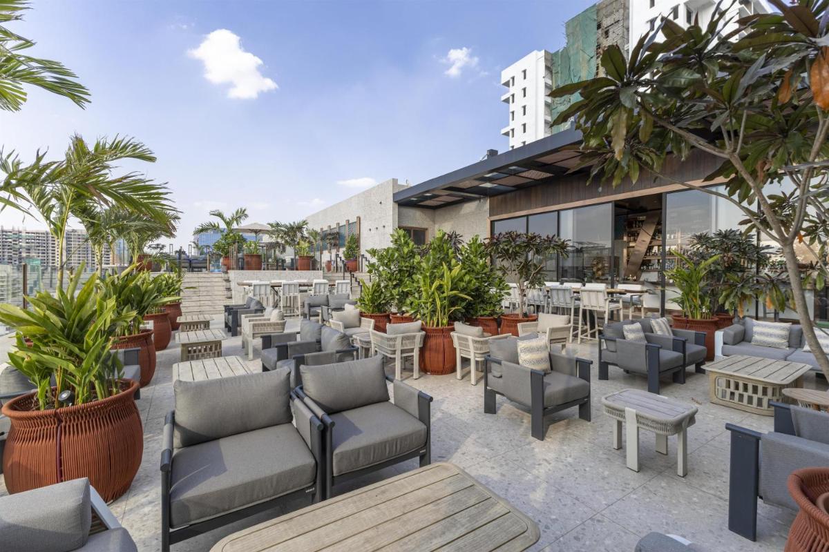 an outdoor patio with chairs and tables and plants at Radisson Blu Hotel Pune Kharadi in Pune