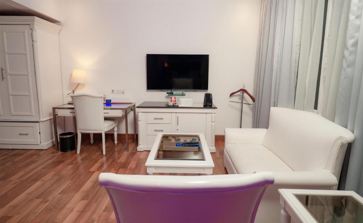 a living room with a white couch and a tv at Radisson Blu Kochi in Cochin