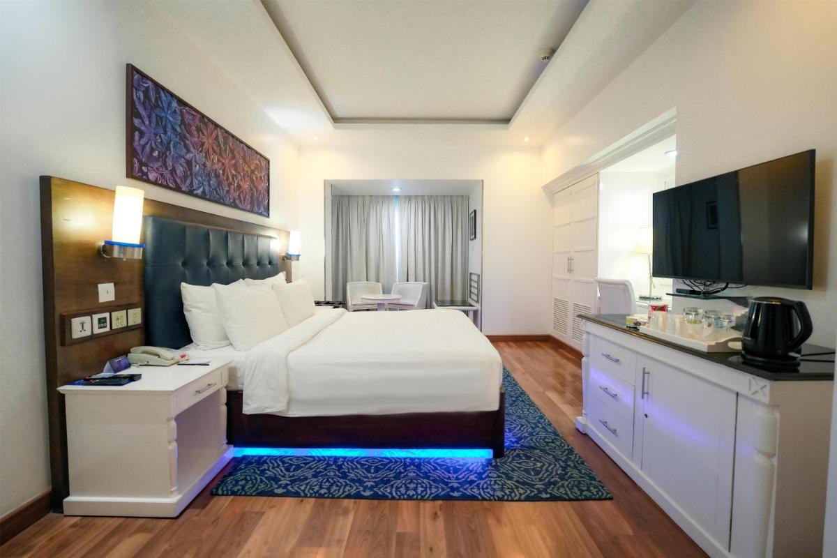 a hotel room with a white bed and a television at Radisson Blu Kochi in Cochin