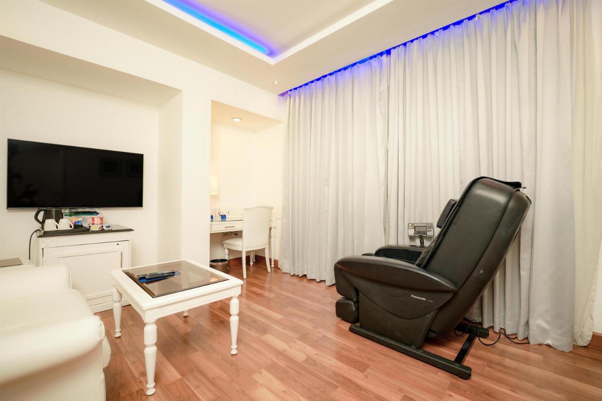 a living room with a black chair and a television at Radisson Blu Kochi in Cochin
