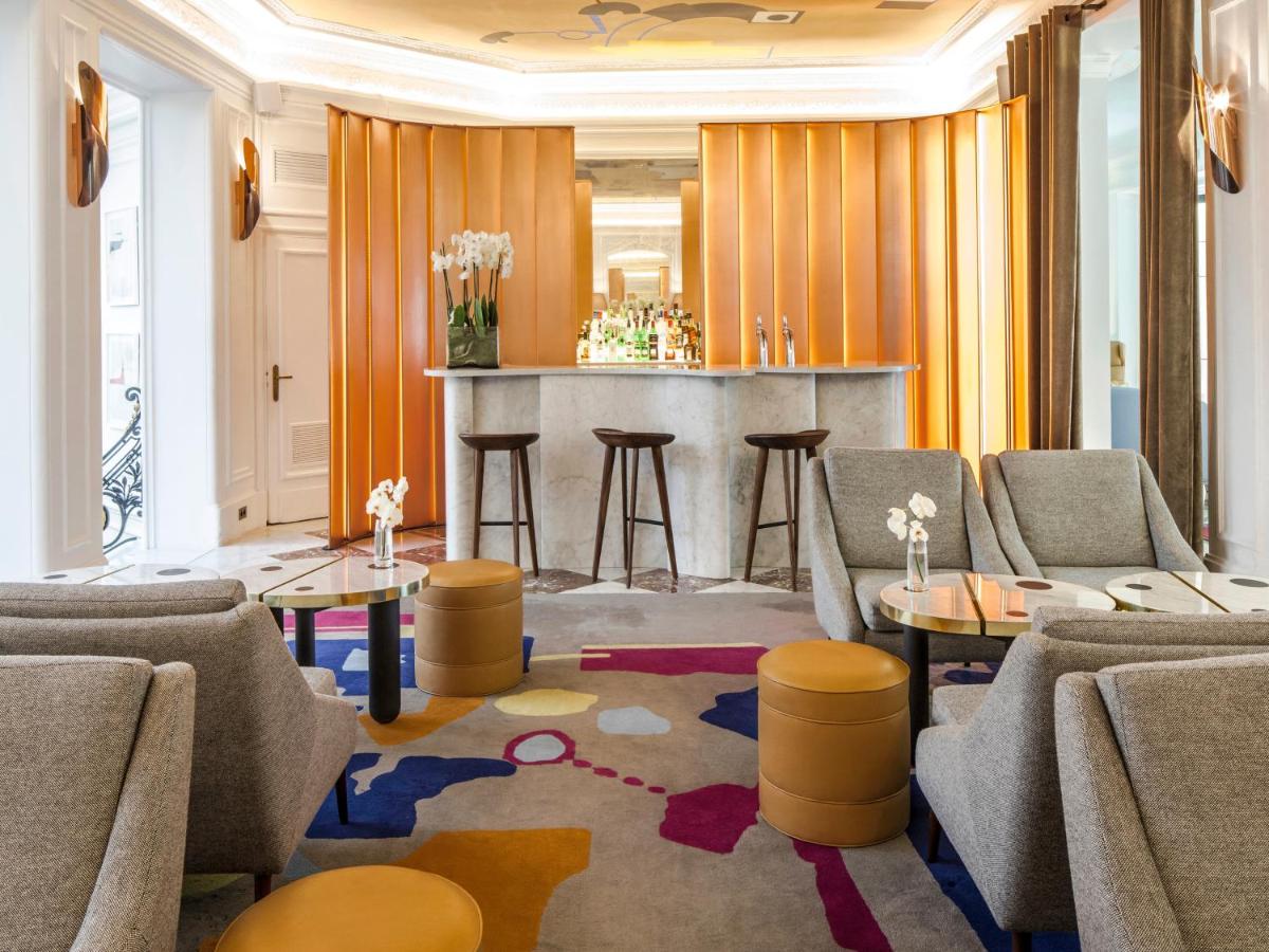 une salle avec des chaises, des tables et un bar dans l'établissement Hôtel Vernet Champs Elysées Paris, à Paris