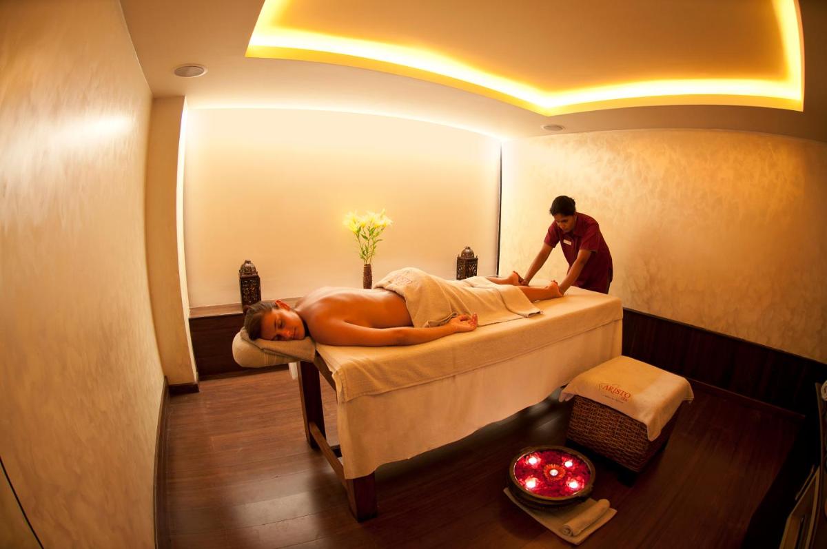 a person laying on a bed in a room at Grand Mercure Bangalore - An Accor Brand in Bengaluru