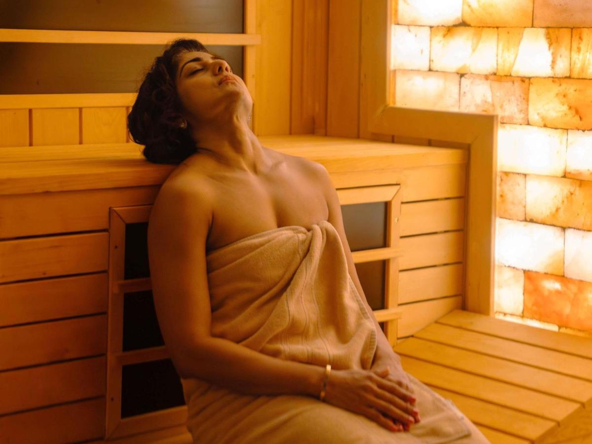 a naked woman sitting in a sauna at Fairmont Mumbai in Mumbai