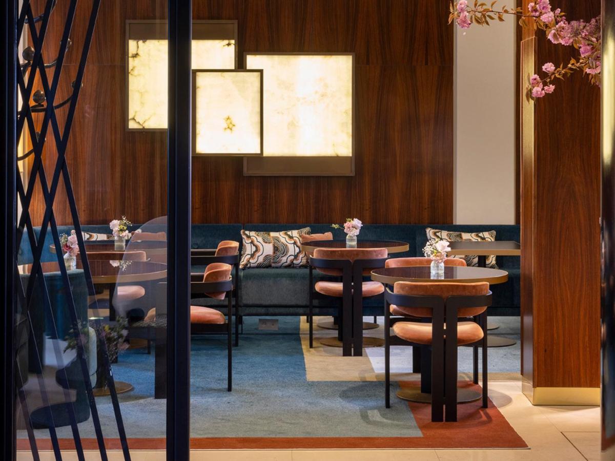 un restaurant avec deux tables et un canapé dans l'établissement Hotel Montalembert, à Paris