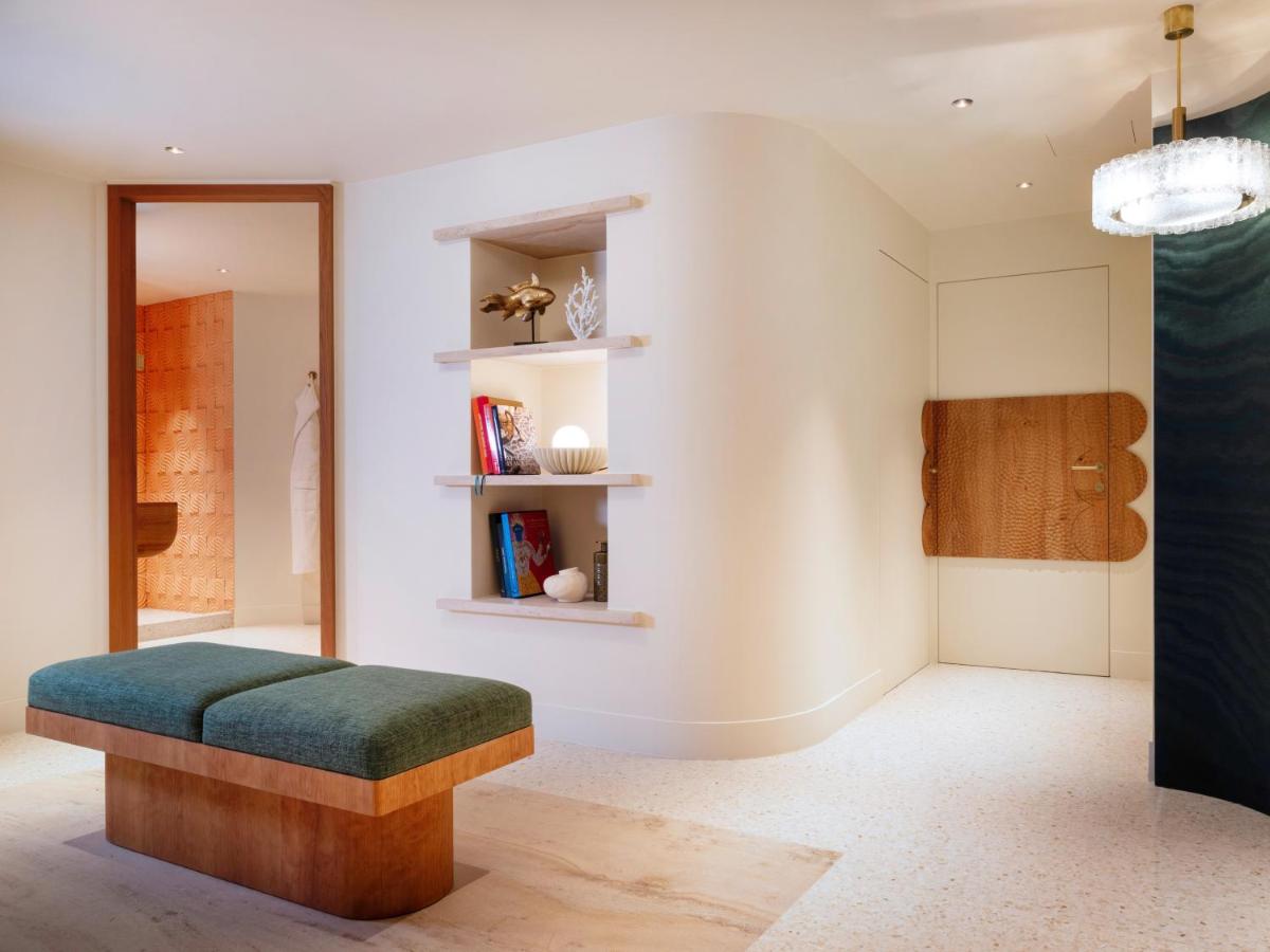 une chambre avec un banc et une bibliothèque dans l'établissement Hotel Montalembert, à Paris