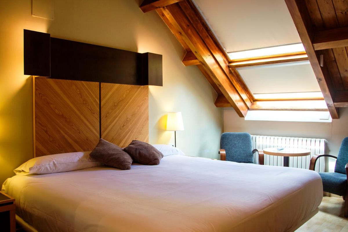 Un dormitorio con una cama grande en una habitación. en Silken Ordesa, en Torla