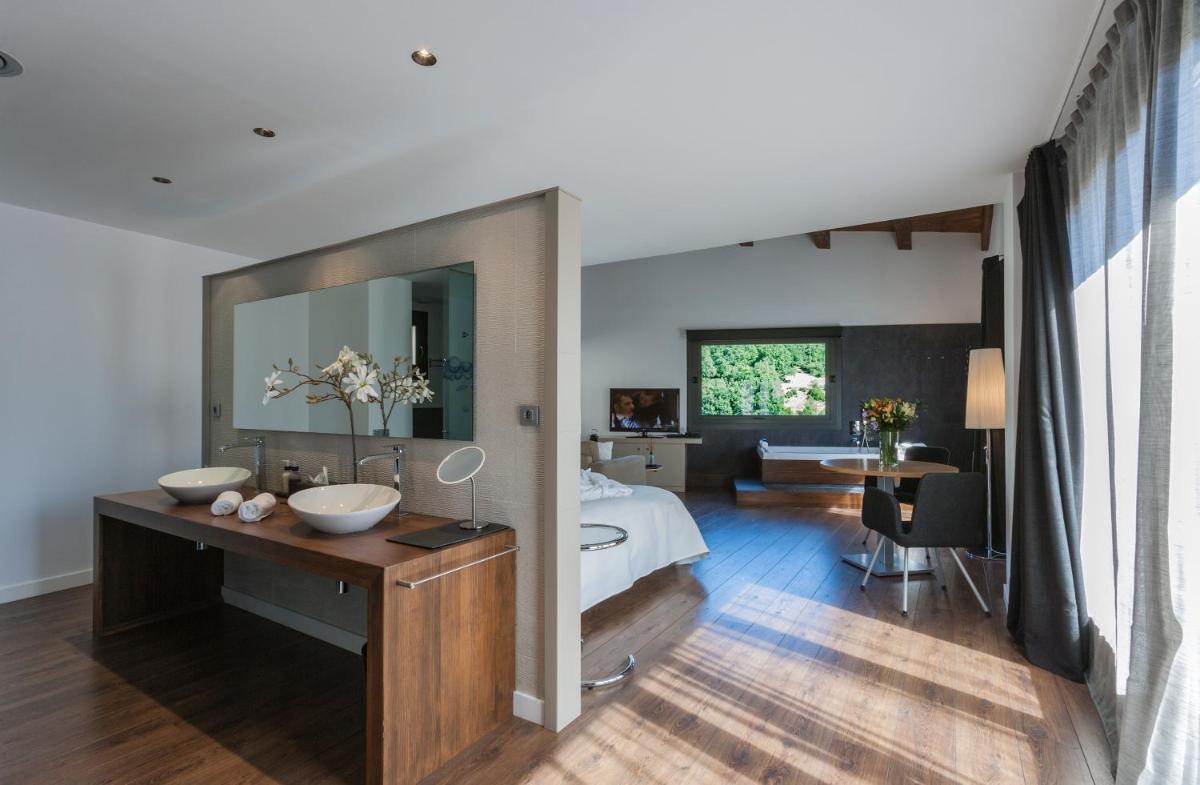 Un dormitorio con una cama y un baño con lavabo. en Bonansa Country Hotel, en Bonansa
