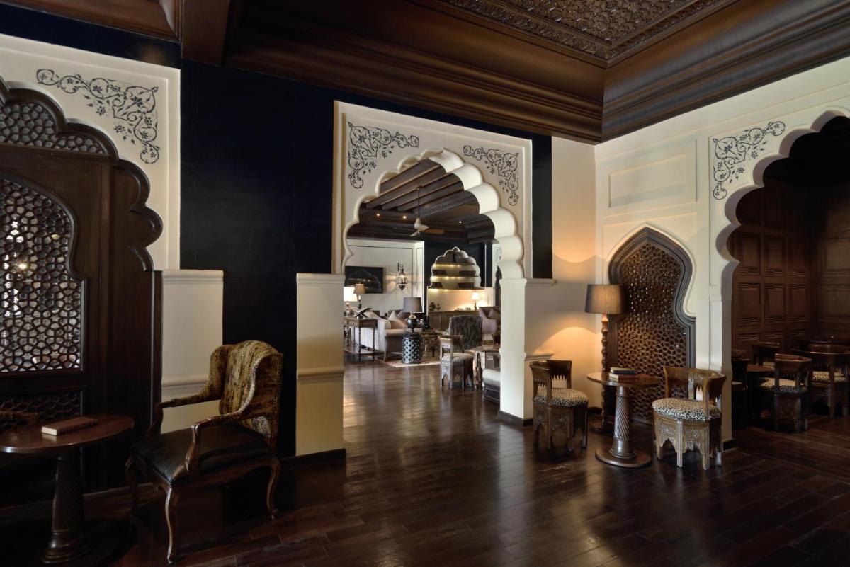 a room with chairs and tables and a room with a ceiling at Fairmont Jaipur in Jaipur