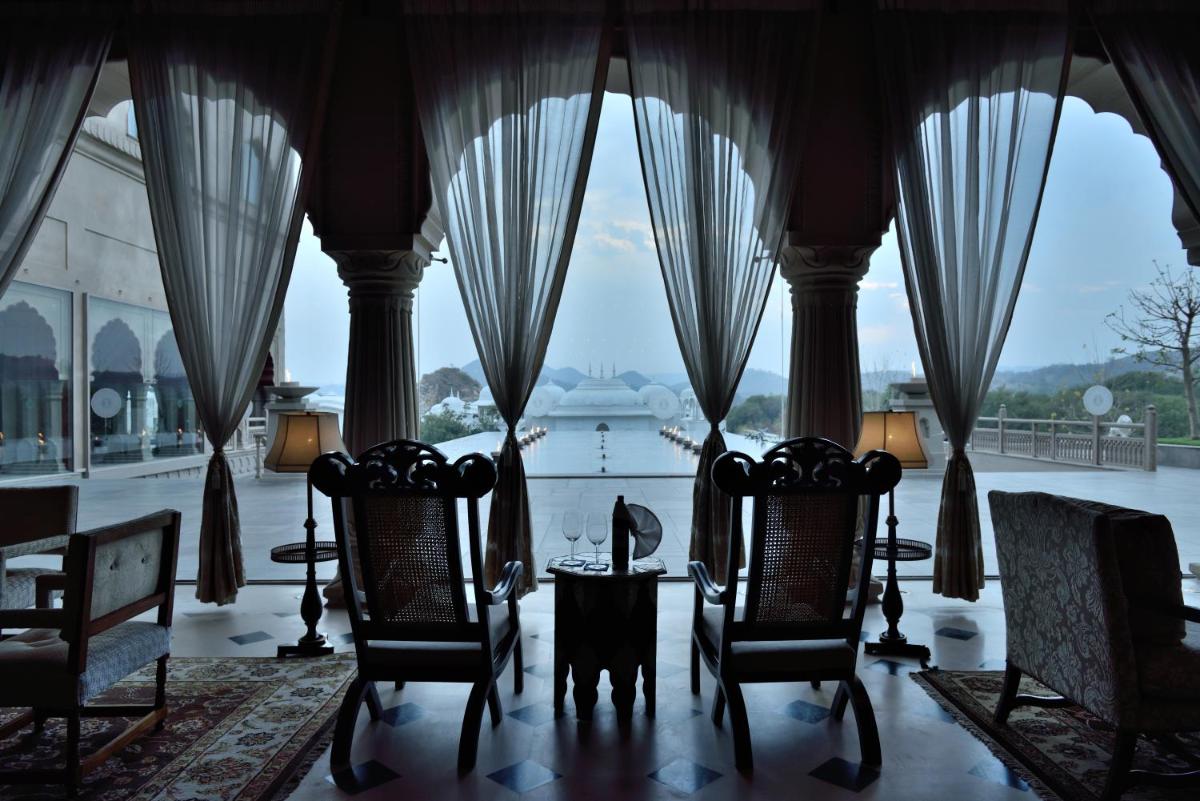 a room with two chairs and a view of the water at Fairmont Jaipur in Jaipur