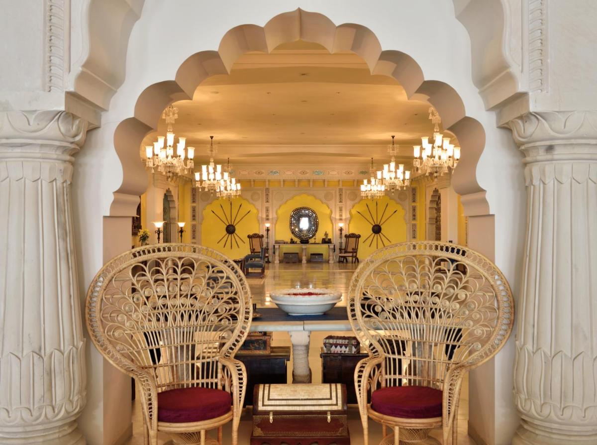 a dining room with two chairs and a table at Fairmont Jaipur in Jaipur