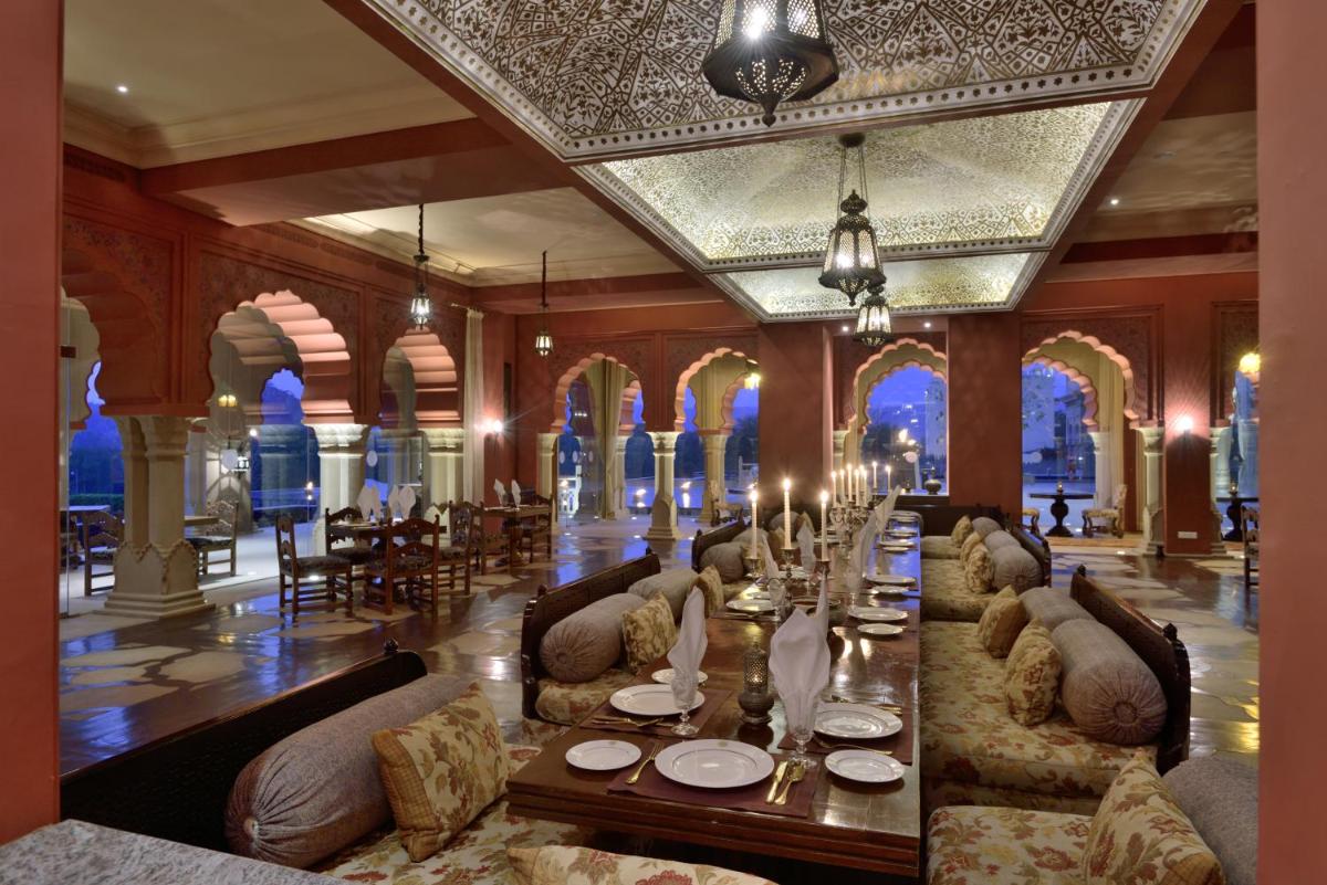 a dining room with a long table and chairs at Fairmont Jaipur in Jaipur