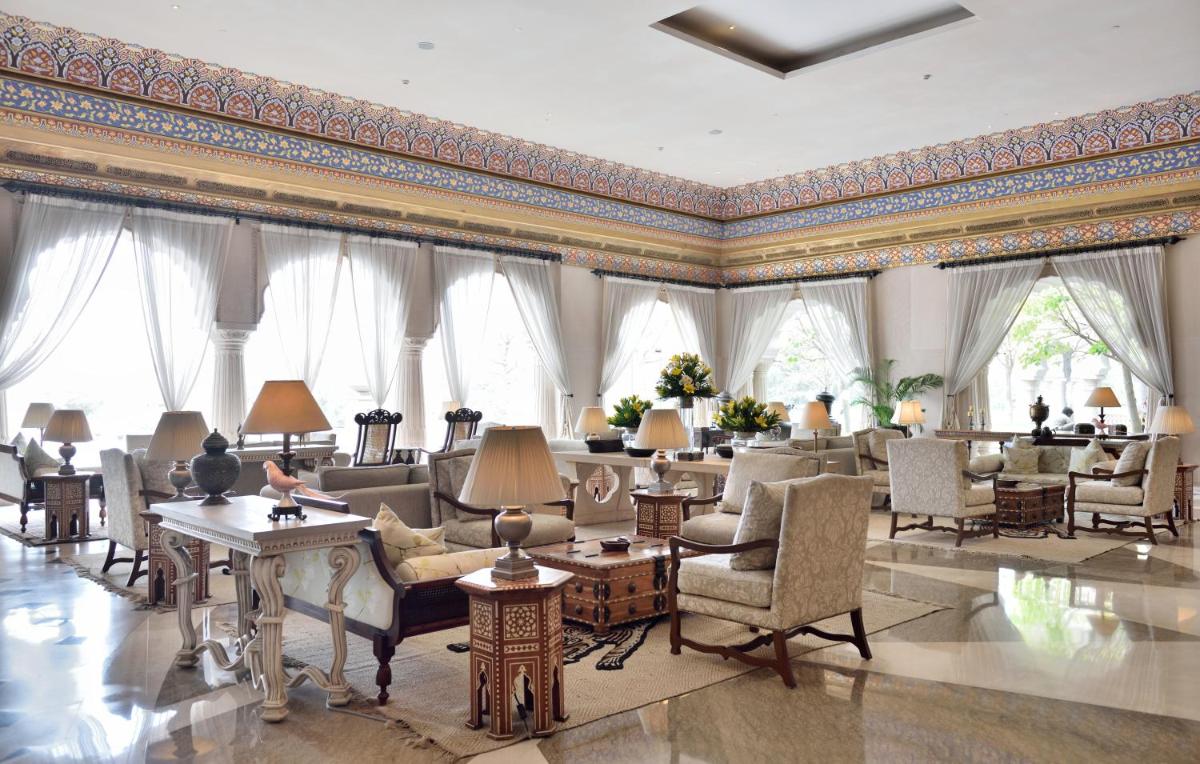 a large room with chairs and tables and windows at Fairmont Jaipur in Jaipur