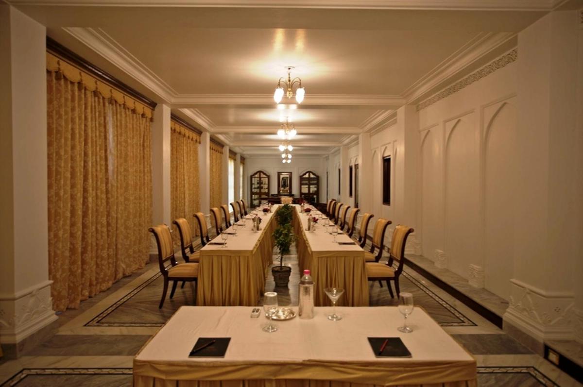 a long dining room with long tables and chairs at The Raj Palace (Small Luxury Hotels of the World) in Jaipur