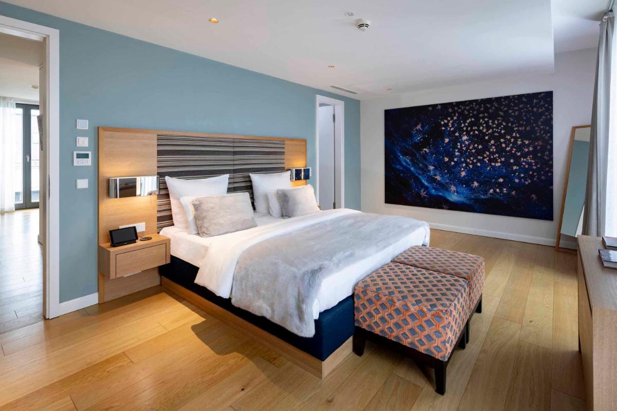 ein Schlafzimmer mit einem großen Bett und einem großen Gemälde in der Unterkunft The Wellem in Düsseldorf