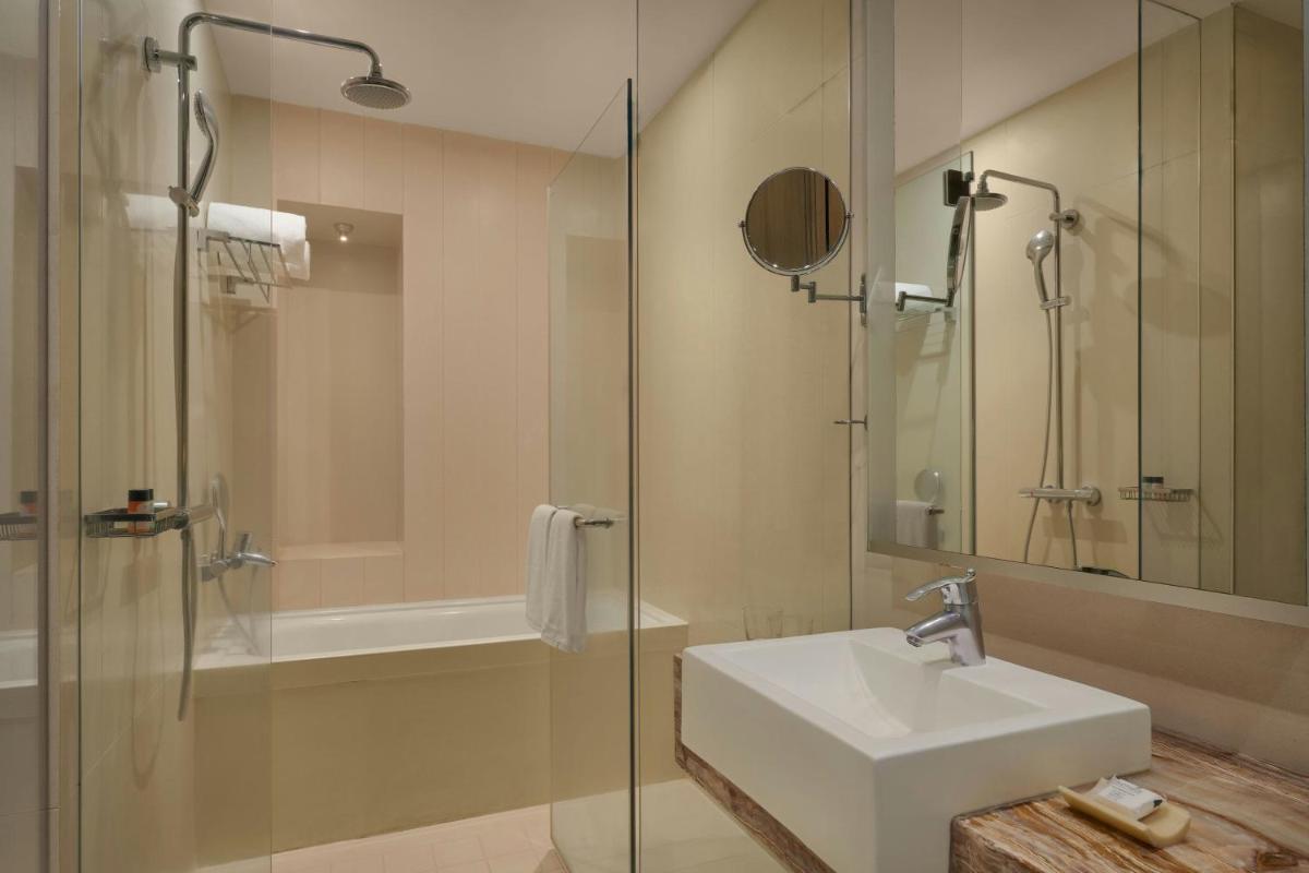 a bathroom with a sink and a glass shower at Meluha The Fern Mumbai, Powai, Series by Marriott in Mumbai