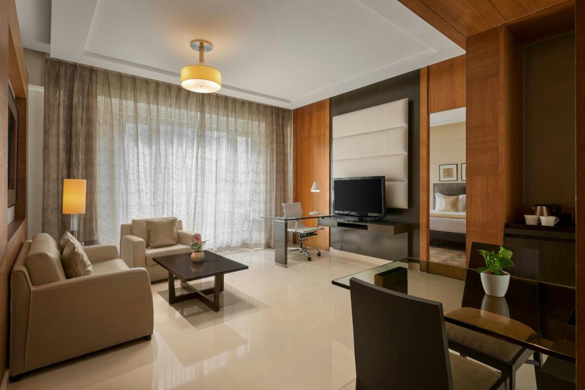 a living room with a couch and a table at Meluha The Fern Mumbai, Powai, Series by Marriott in Mumbai