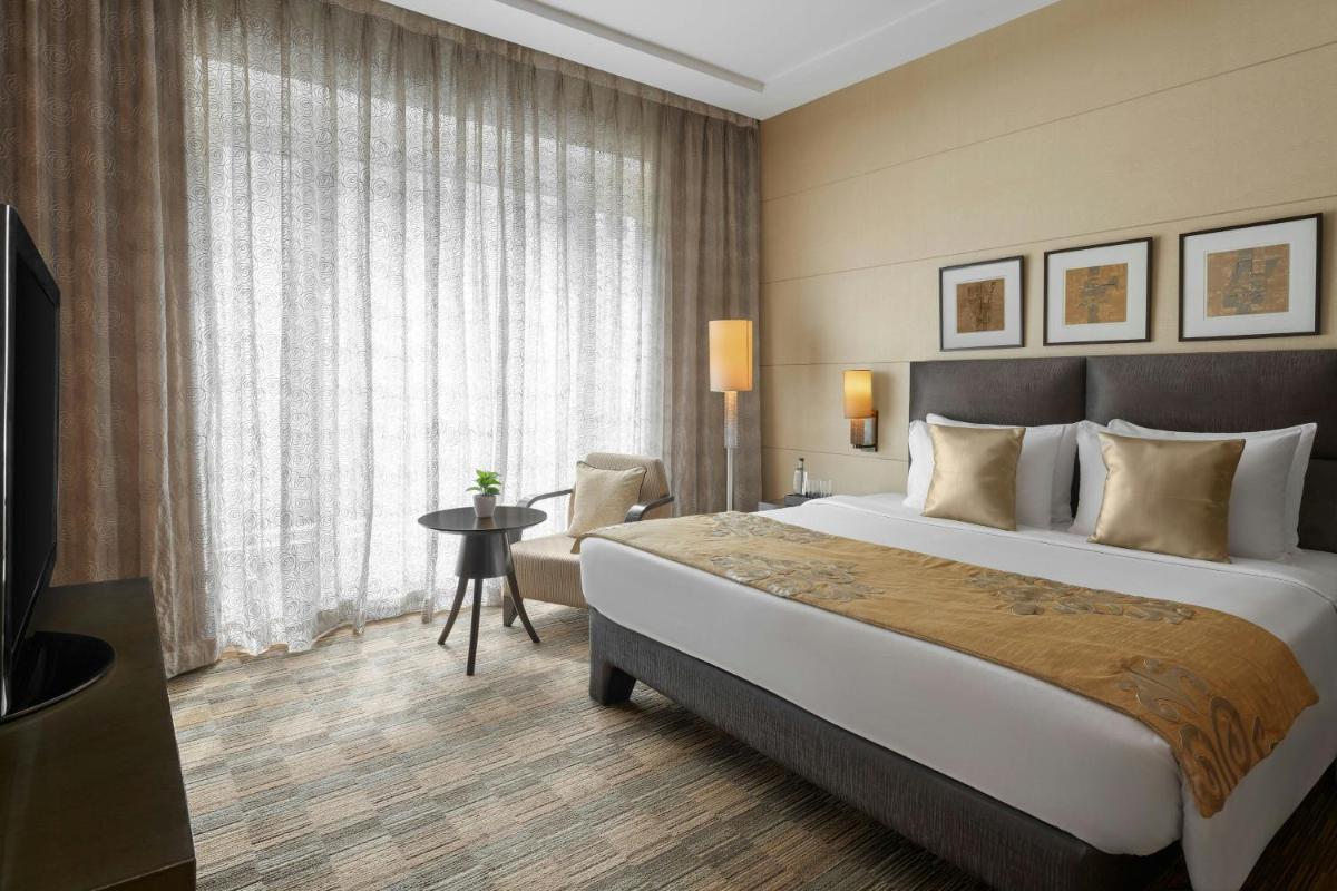 a hotel room with a large bed and a window at Meluha The Fern Mumbai, Powai, Series by Marriott in Mumbai