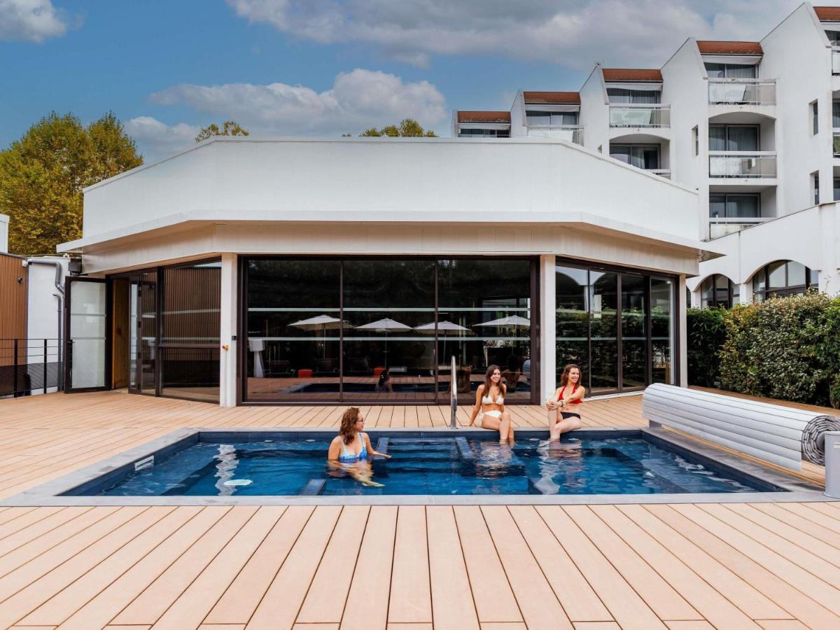 trois filles assises dans une piscine dans un bâtiment dans l'établissement Mercure Aix-les-Bains Domaine de Marlioz Hôtel & Spa, à Aix-les-Bains
