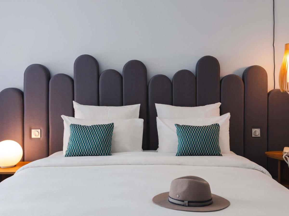 une chambre avec un grand lit sur lequel il y a un chapeau dans l'établissement Mercure Aix-les-Bains Domaine de Marlioz Hôtel & Spa, à Aix-les-Bains 201 autres photos