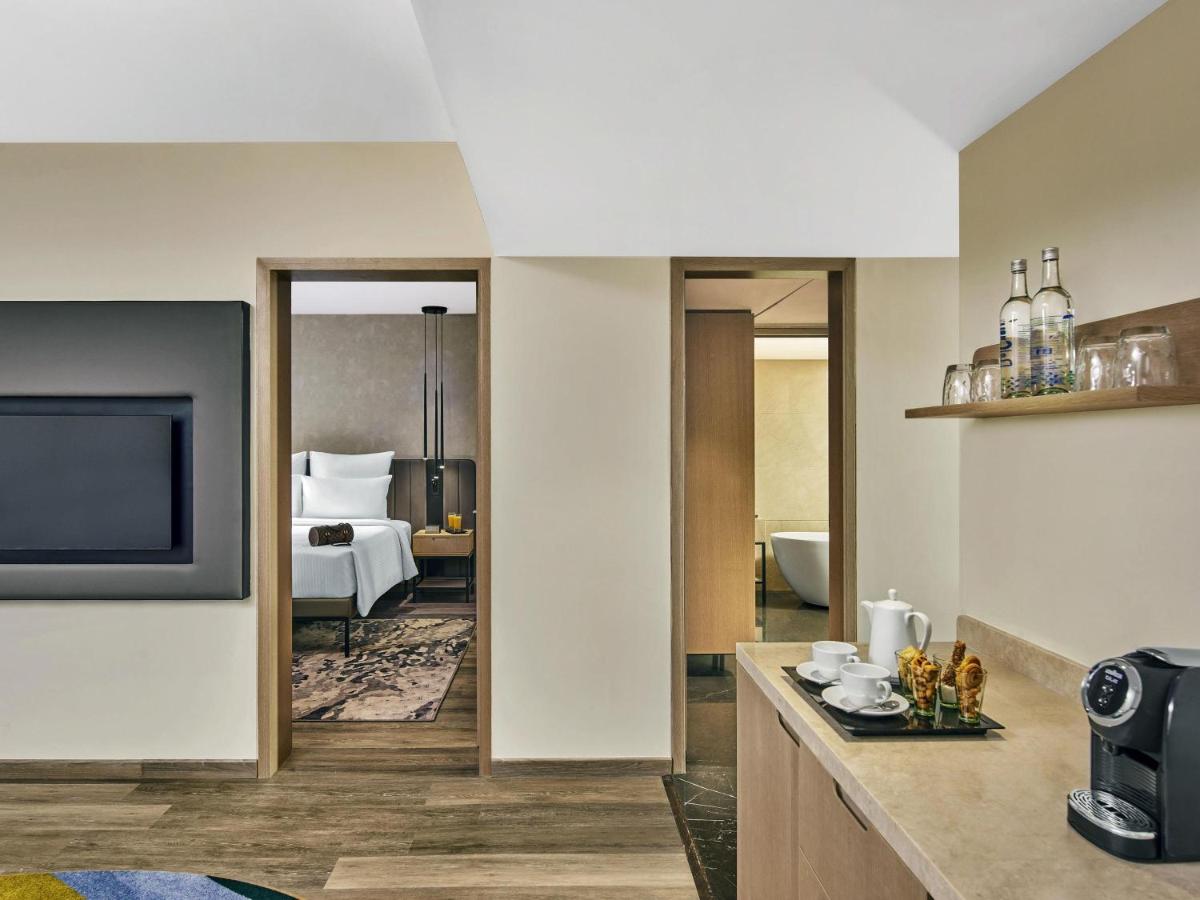 a hotel room with a bed and a television at Novotel Mumbai International Airport in Mumbai