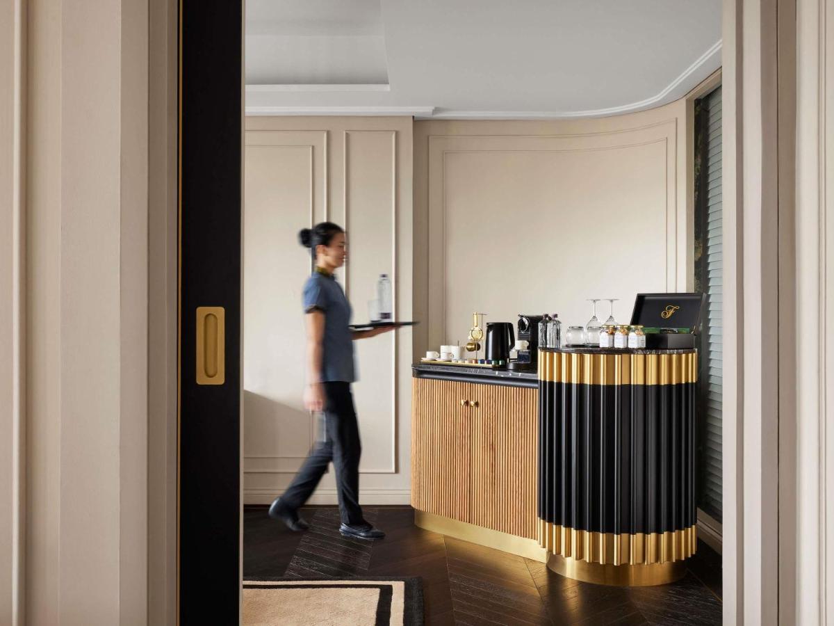 a woman is walking through a hotel room at Fairmont Mumbai in Mumbai