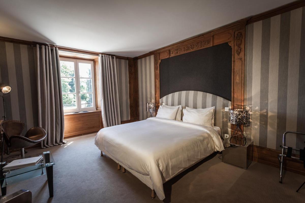 une chambre avec un grand lit et une fenêtre dans l'établissement Le Château D'orfeuillette, à La Garde