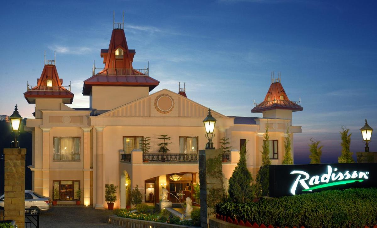 a large building with a sign in front of it at Radisson Hotel Shimla in Shimla