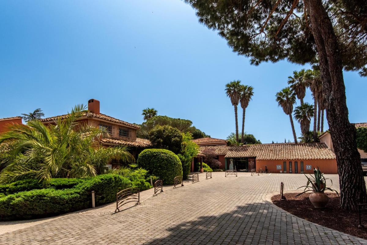 une cour avec des chaises en face d'un bâtiment dans l'établissement Villa Duflot Hôtel & Spa Perpignan, à Perpignan