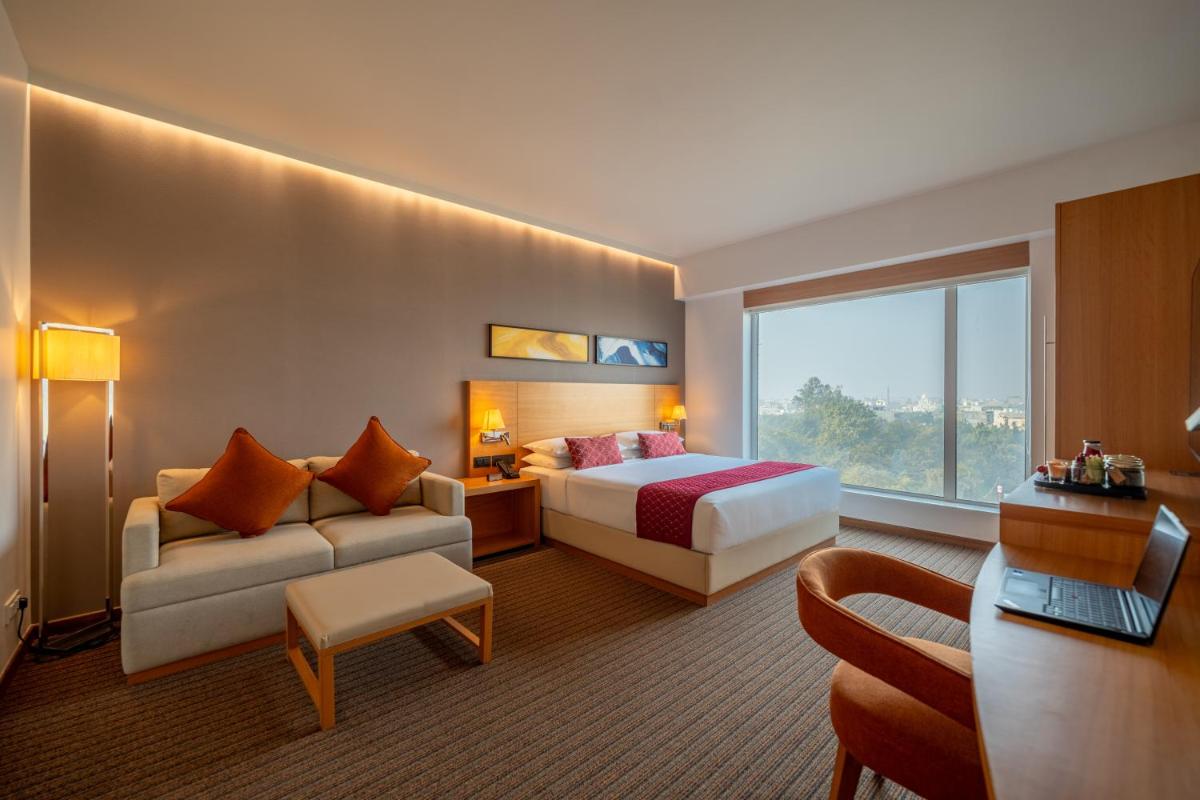 a hotel room with a bed and a couch at Hyatt Place Gurgaon Udyog Vihar in Gurgaon a hotel room with a bed and a couch at Hyatt Place Gurgaon Udyog Vihar in Gurgaon