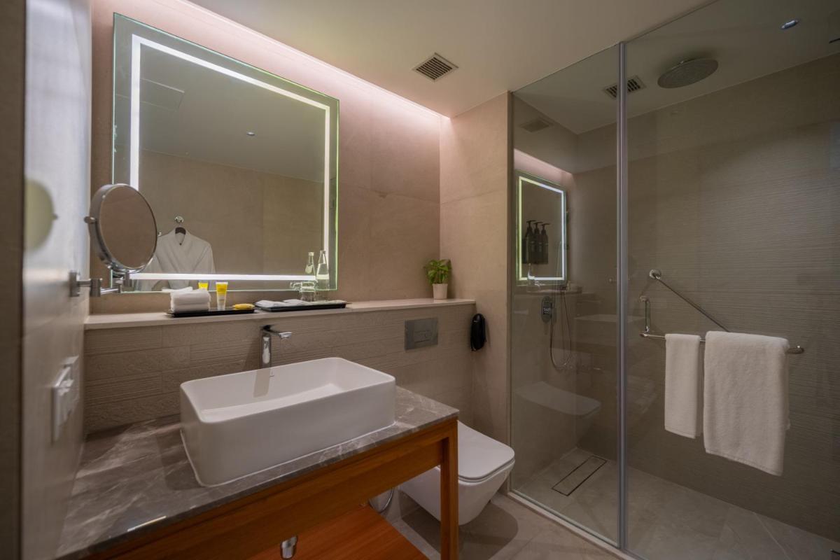a bathroom with a sink and a toilet and a shower at Hyatt Place Gurgaon Udyog Vihar in Gurgaon