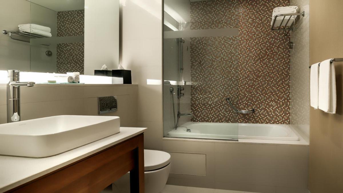 a bathroom with a sink and a toilet and a shower at Hyatt Place Gurgaon Udyog Vihar in Gurgaon