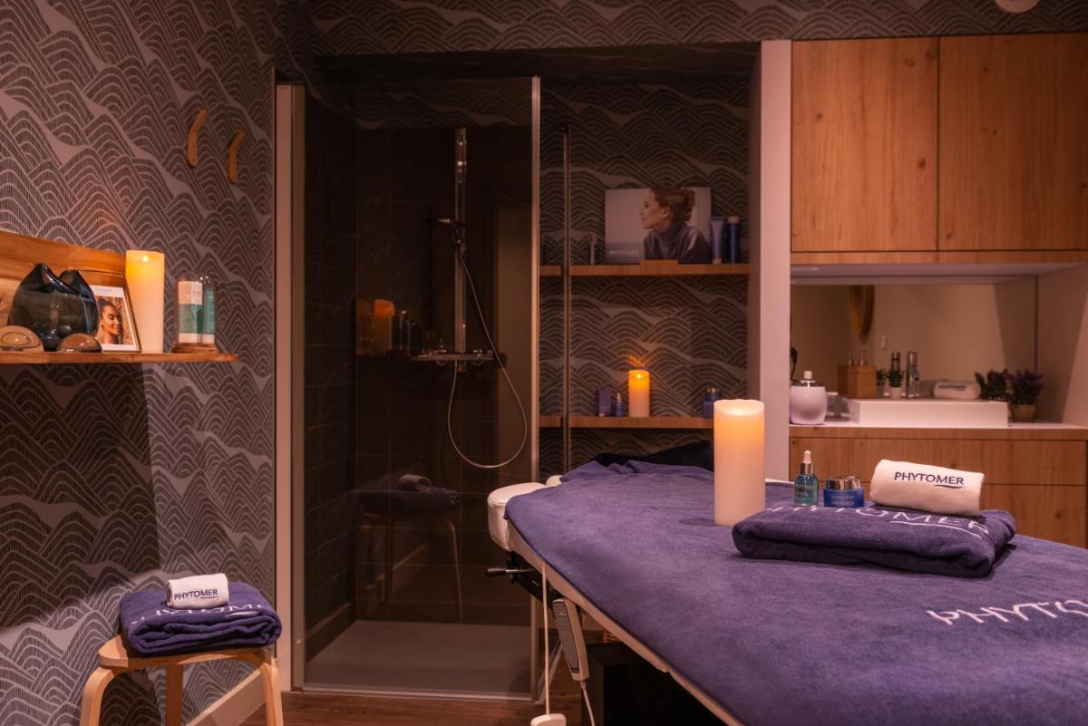 une salle de bain avec une table violette sur laquelle est posée une bougie dans l'établissement Golden Tulip Saint Malo– Le Grand Bé, à Saint-Malo