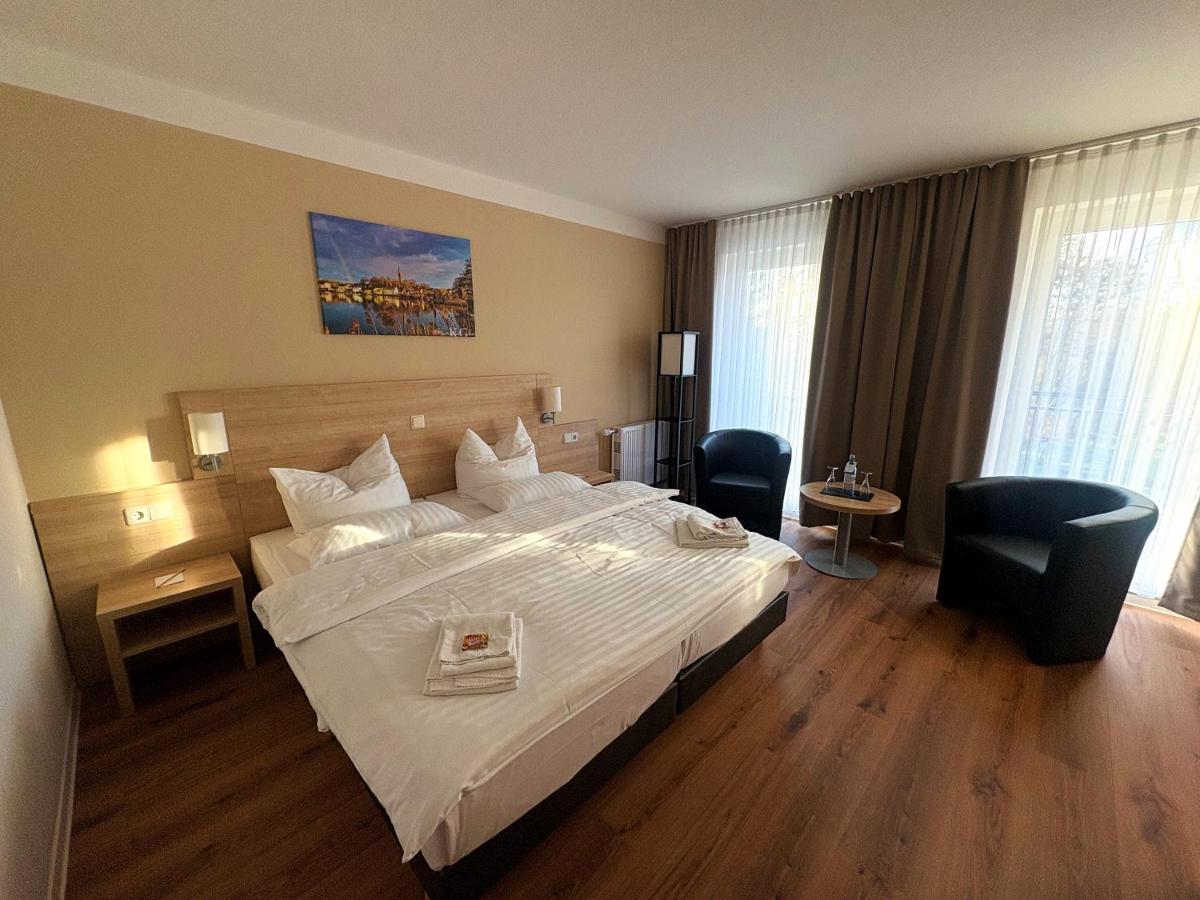ein Hotelzimmer mit einem großen Bett und zwei Stühlen in der Unterkunft Kaiserhof Feldberg by Belvilla Resorts in Feldberg