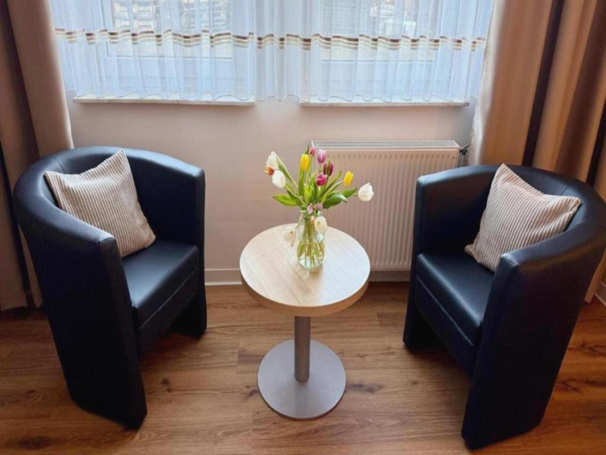 zwei Stühle und ein Tisch mit einer Blumenvase in der Unterkunft Kaiserhof Feldberg by Belvilla Resorts in Feldberg