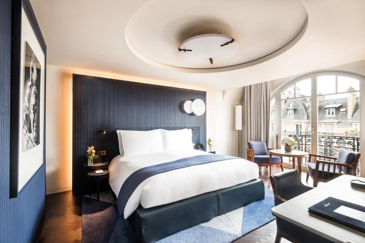 une chambre d'hôtel avec un lit, une table et des chaises dans l'établissement Mandarin Oriental Lutetia, Paris, à Paris une chambre d'hôtel avec un lit, une table et des chaises dans l'établissement Mandarin Oriental Lutetia, Paris, à Paris