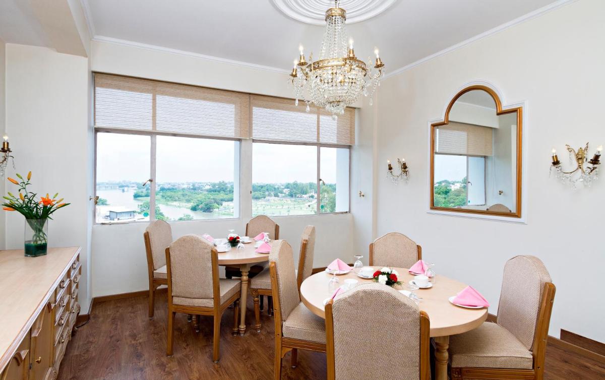 a dining room with tables and chairs and a chandelier at Clarks Avadh in Lucknow
