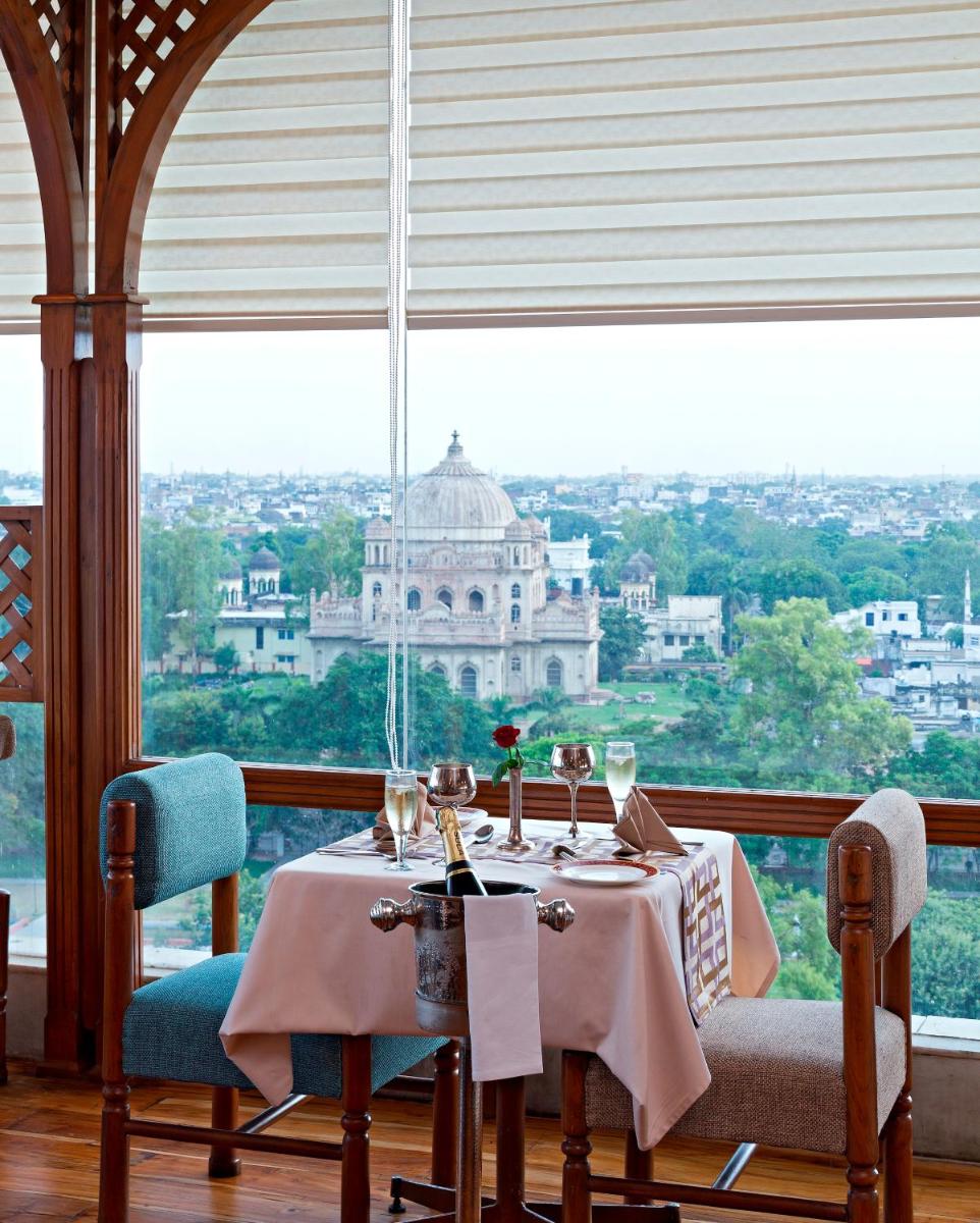 a dining room table with a view of a building at Clarks Avadh in Lucknow