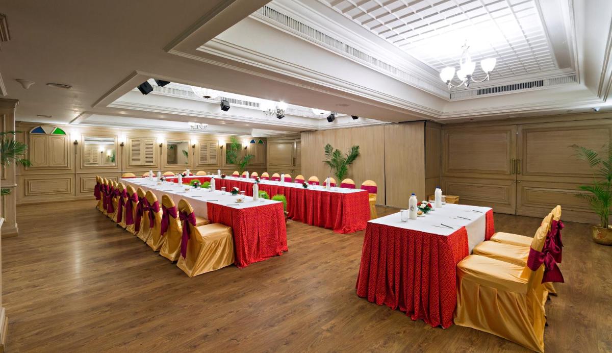 a conference room with tables and chairs with red tablecloths at Clarks Avadh in Lucknow