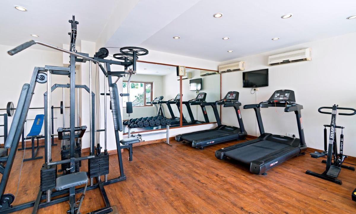 a gym with several tread machines in a room at Clarks Avadh in Lucknow