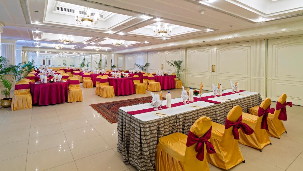 a banquet hall with red and yellow tables and chairs at Clarks Avadh in Lucknow