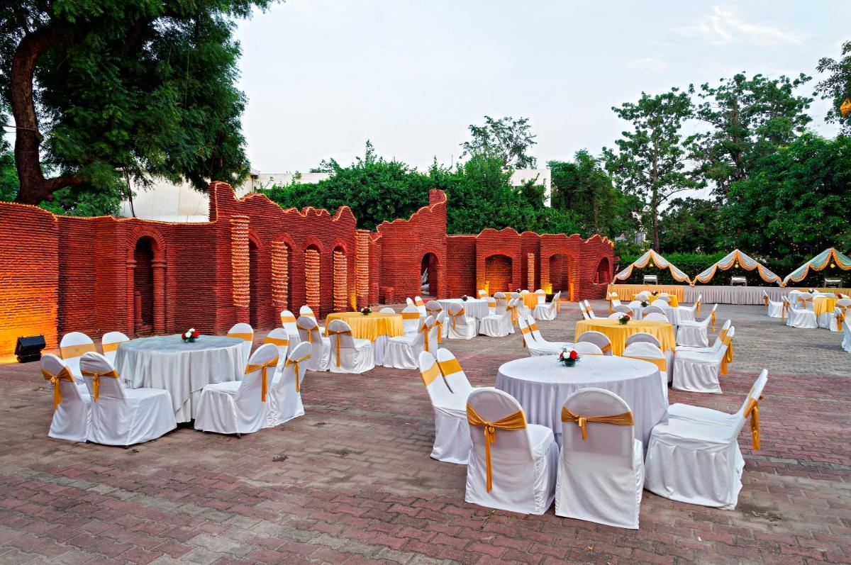 a group of tables and chairs in front of a brick building at Clarks Avadh in Lucknow