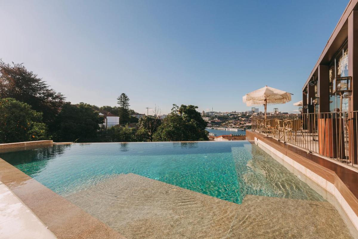 uma piscina com um guarda-sol na lateral de um prédio em Torel Avantgarde no Porto