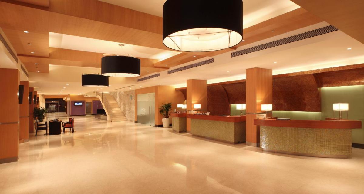 a lobby of a hotel with a reception desk at Novotel Mumbai Juhu Beach in Mumbai