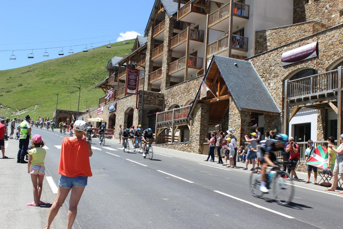 un groupe de personnes faisant du vélo dans une rue dans l'établissement Résidence Mer & Golf Tourmalet, à La Mongie