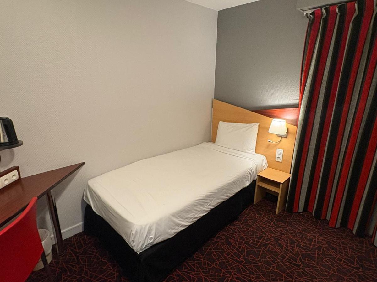 Un ou plusieurs lits dans un hébergement de l'établissement Kyriad Hotel Dijon Gare