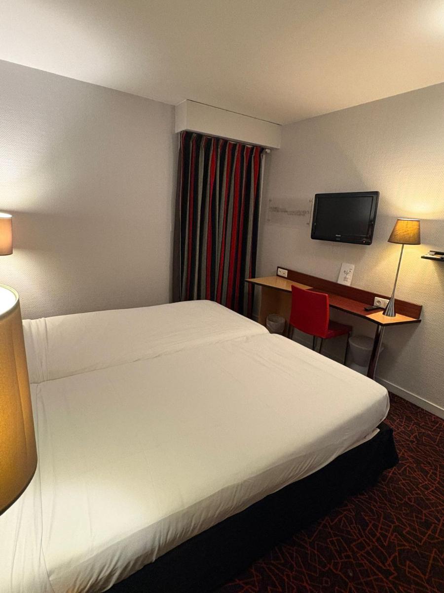 Un ou plusieurs lits dans un hébergement de l'établissement Kyriad Hotel Dijon Gare